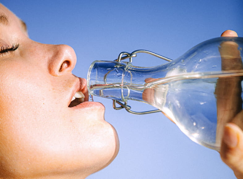 Donna che beve acqua per soddisfare la sensazione di sete